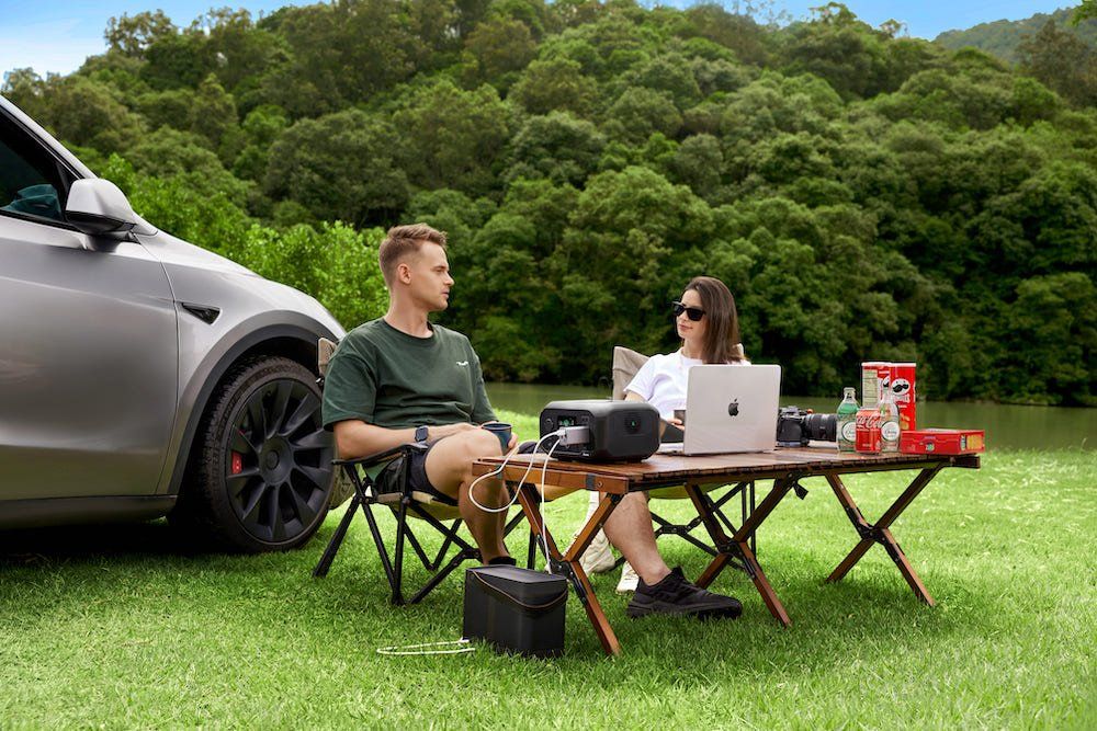 a photo of a couple camping and using Ampace Andes 300 to power their devices on a camp site.