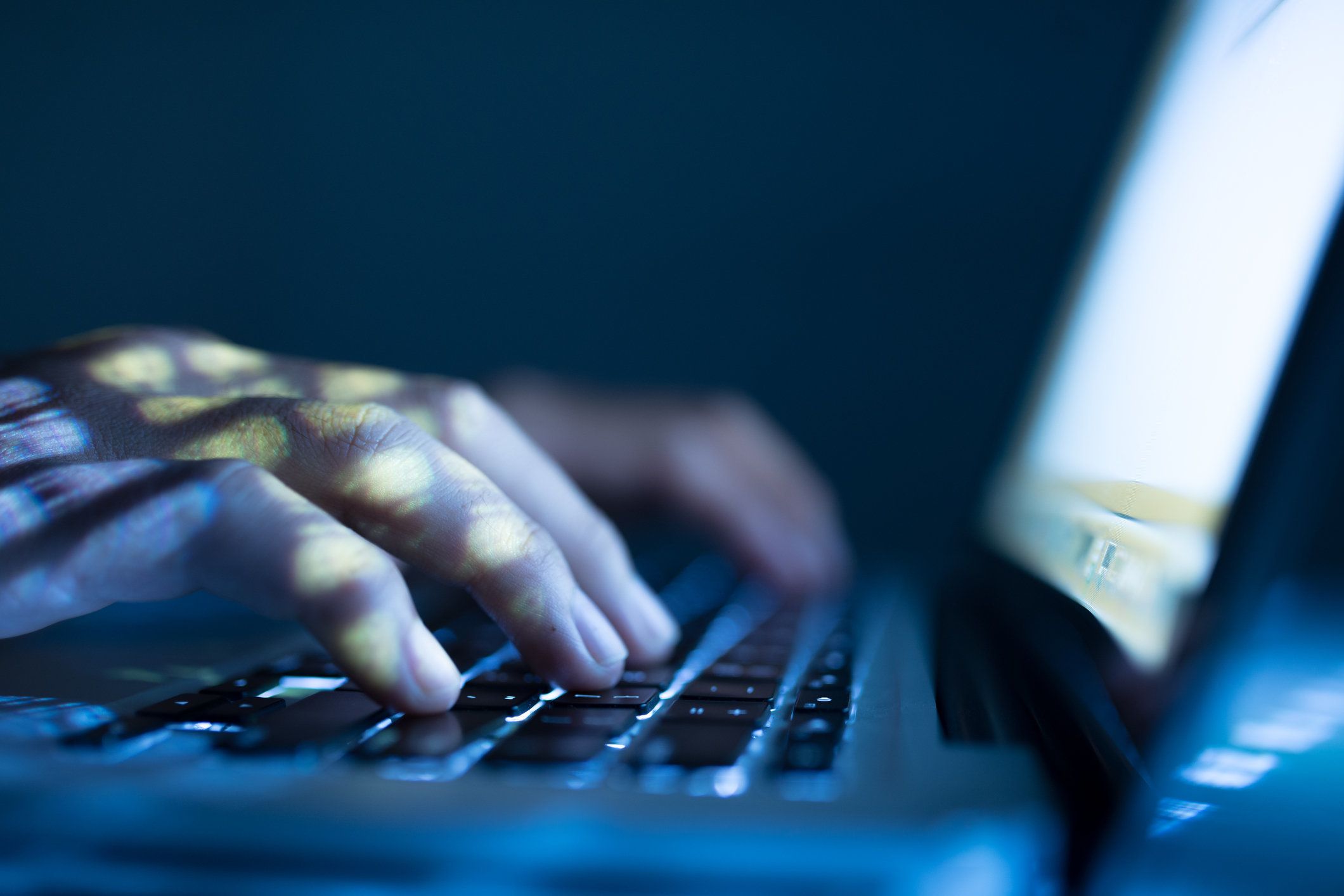 man typing on a laptop at night