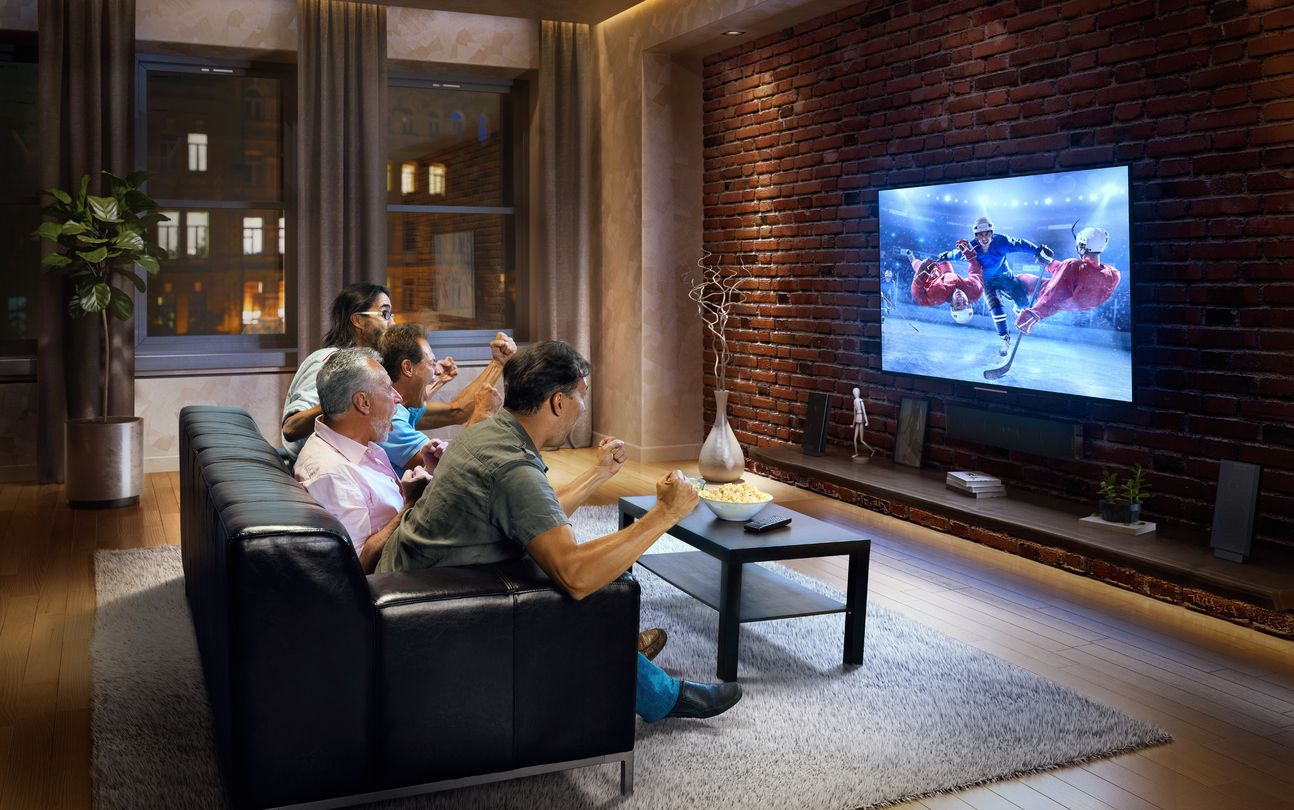 a photo of men watching a sporting event while sitting on a couch