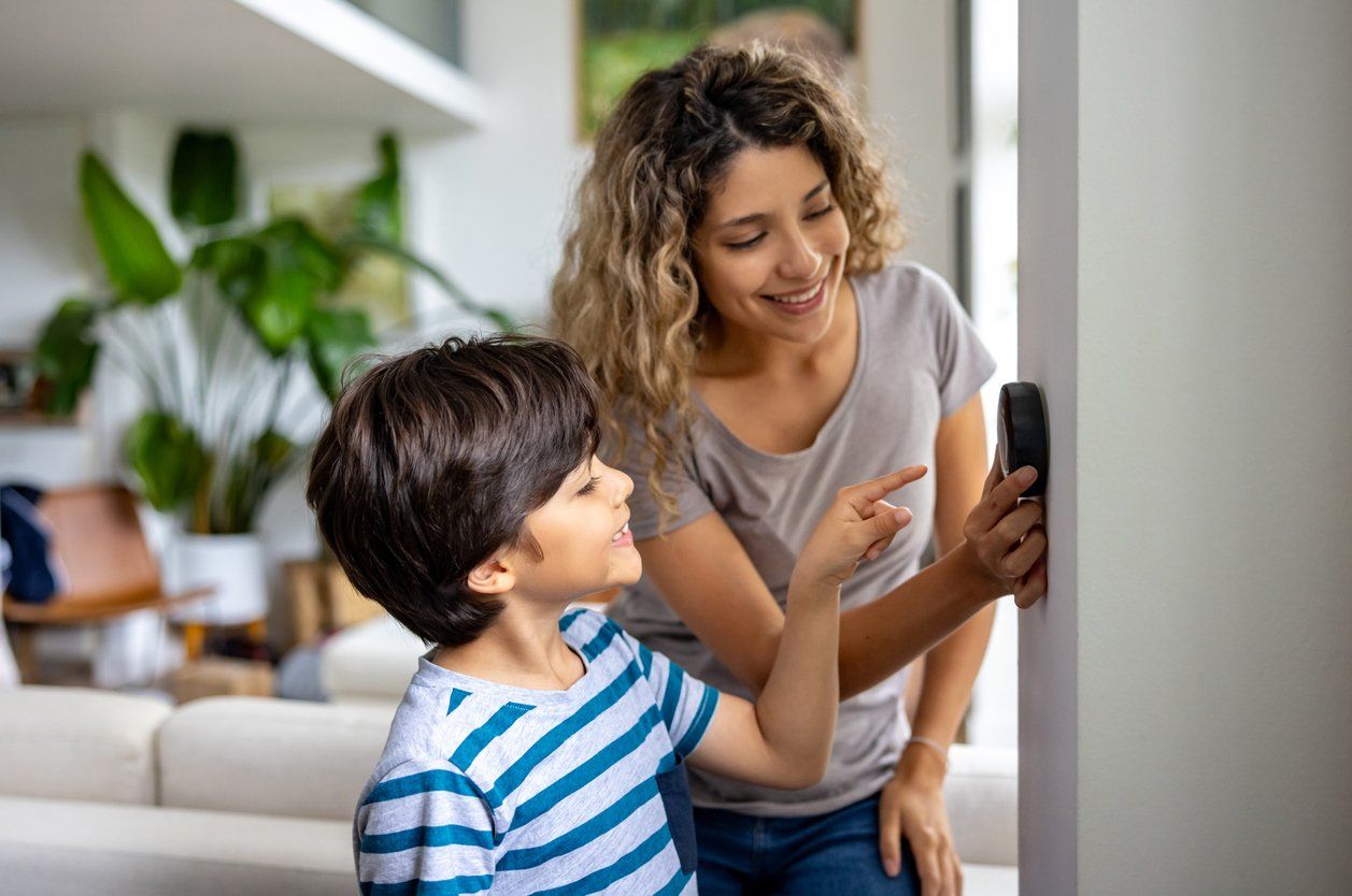 a photo of a mother and son using a smart theremostat