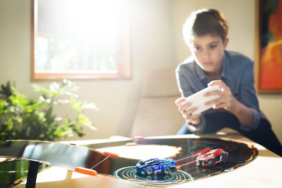 a photo of a young boy playing with remote control cars