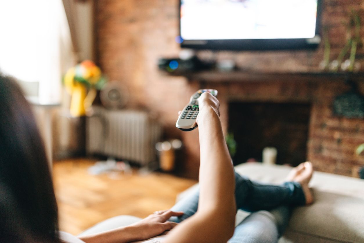 a photo of woman watching tv with streaming media device