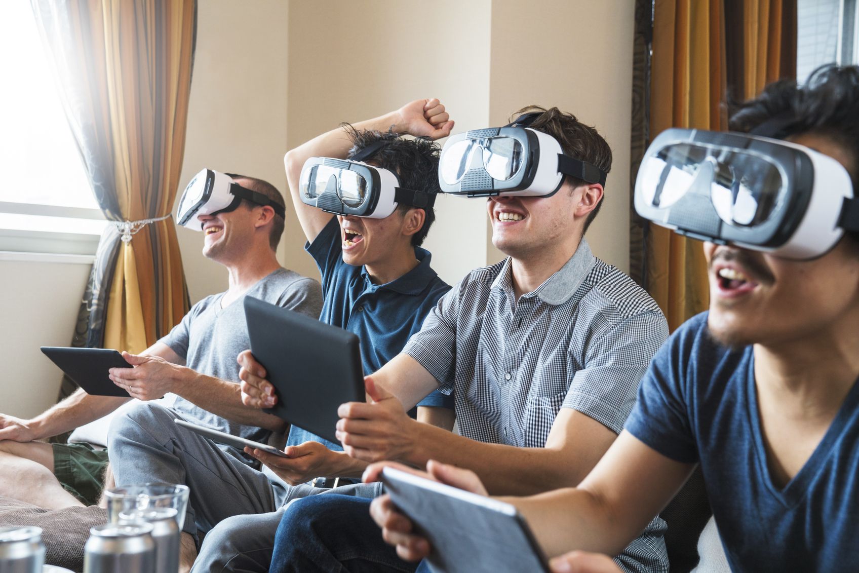 a photo of four men wearing VR headsets and playing a game.