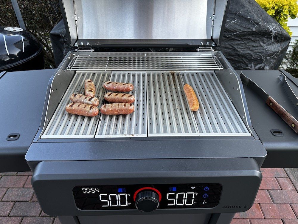 a photo of cooking sausage on Current Model G Dual Zone electric grill