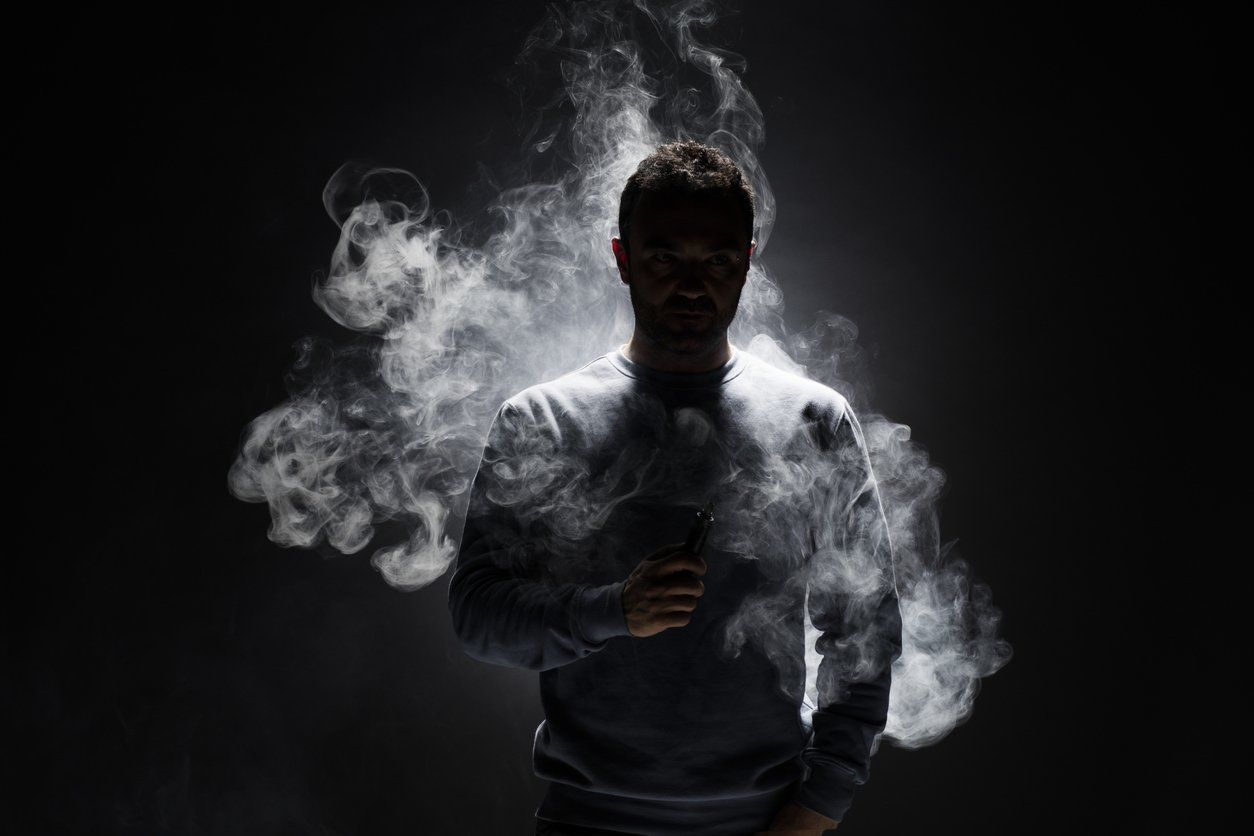 a photo of a man surrounded by smoke in the dark