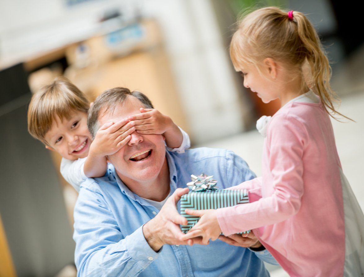 a photo of two children giving their Dad his Father's Day gift.