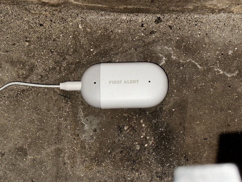 a photo of First Alert L1 WiFi Water Leak Detector installed on a basement floor