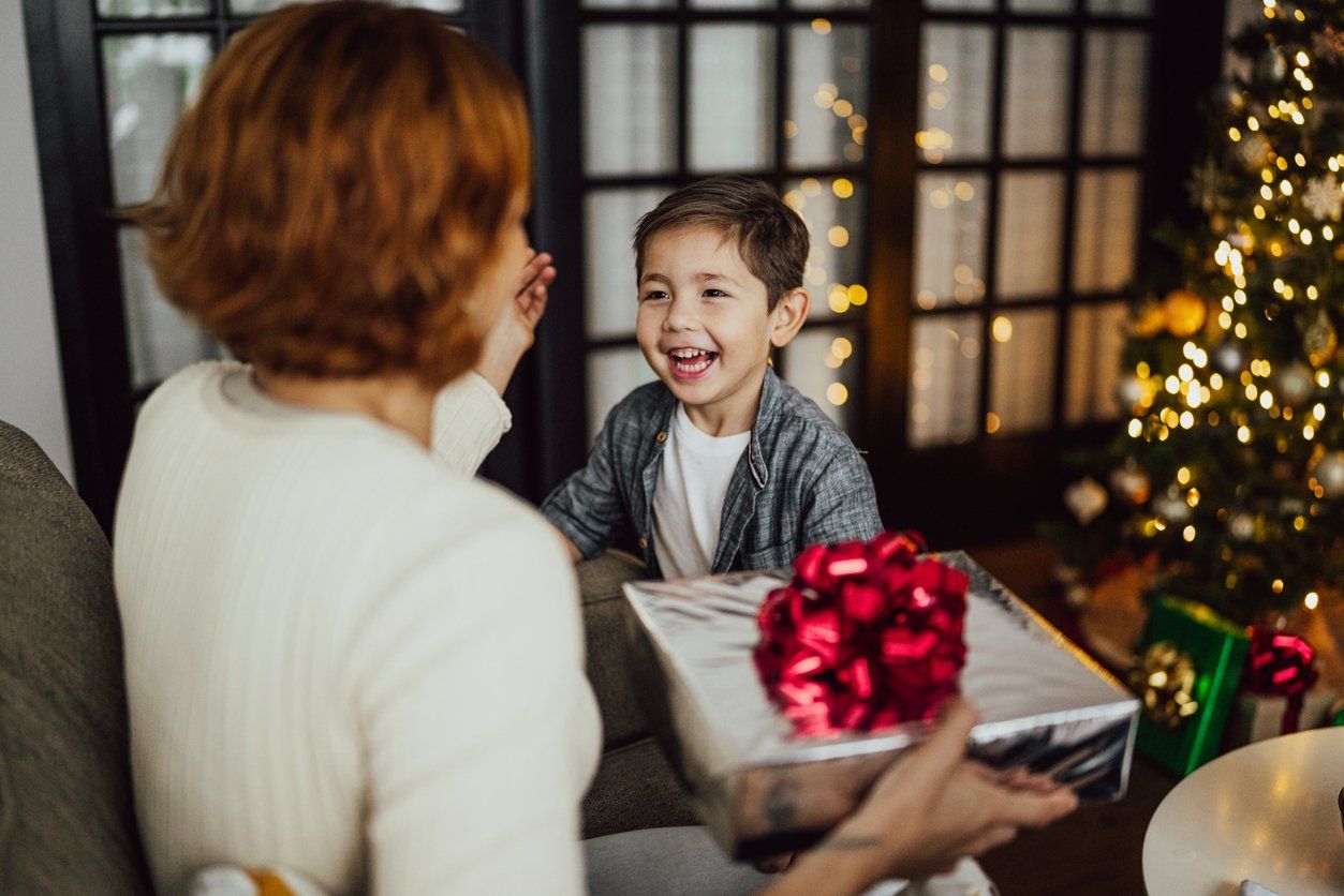 a photo of a mother receiving a gift from her son.