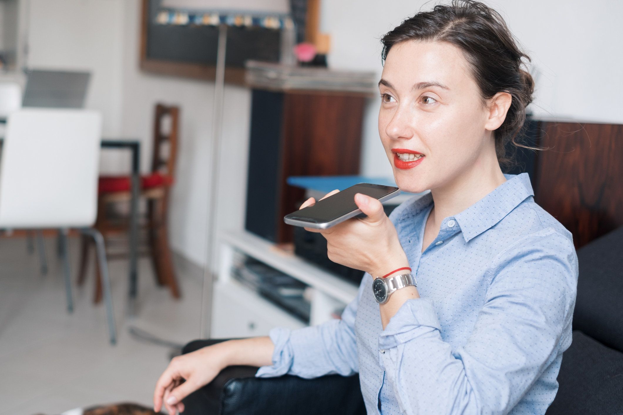 a woman speaking into a smartphone photo