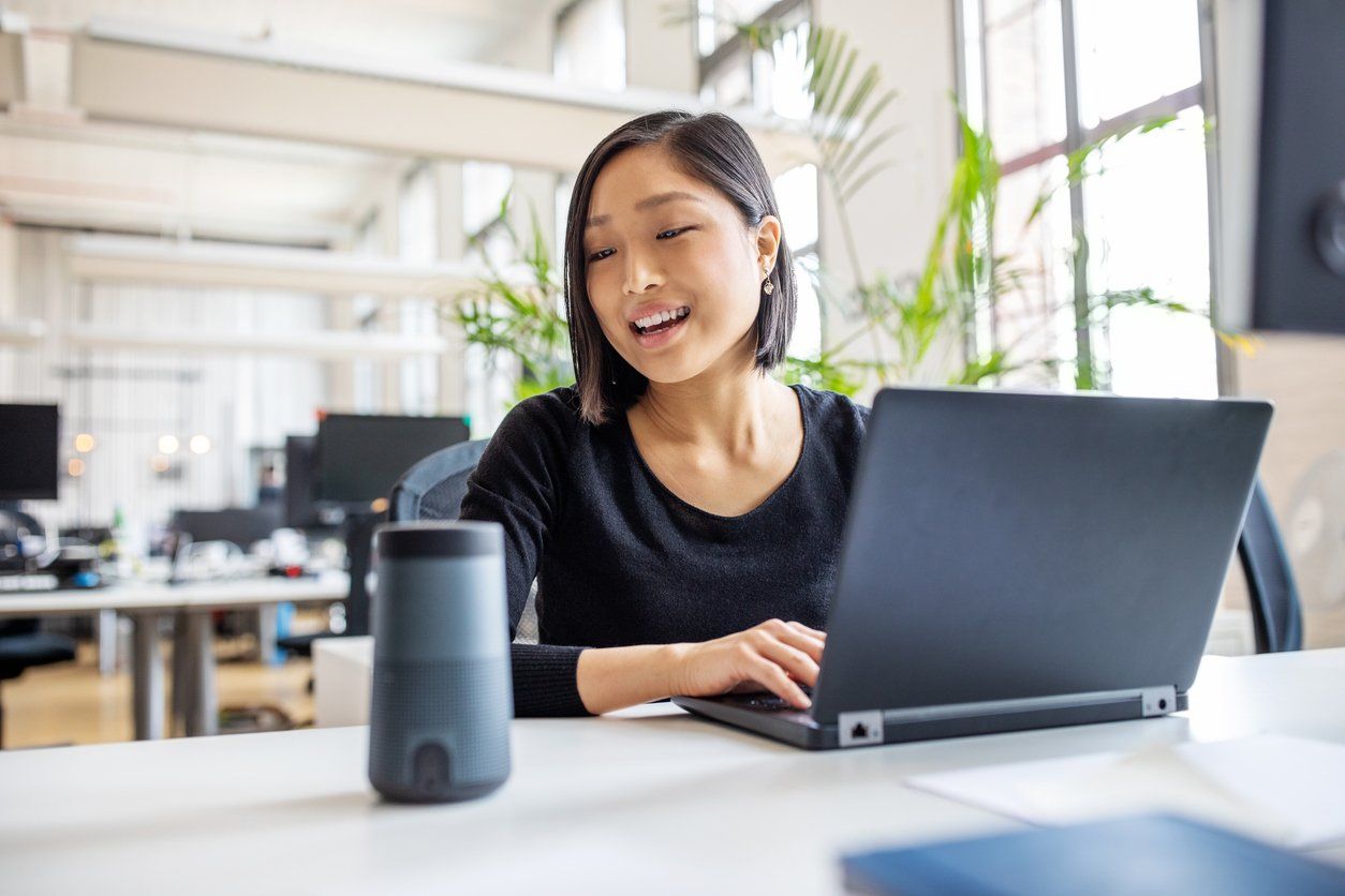 Female professional using virtual assistant at desk stock photo