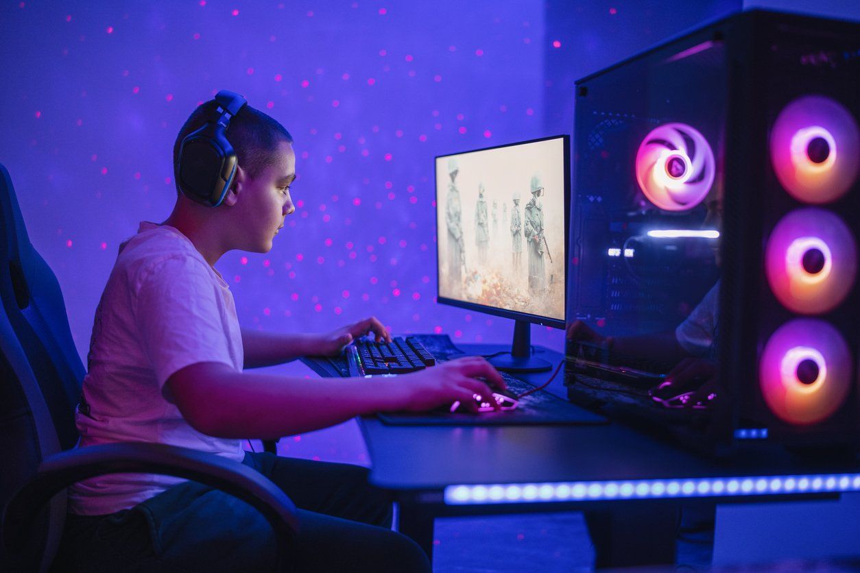 Teenager addicted to video games playing on a computer. stock photo