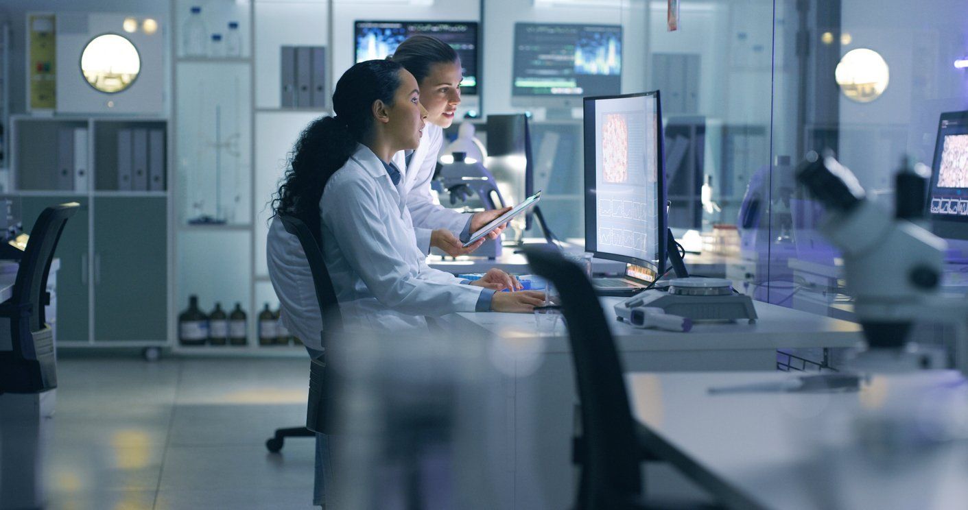 a photo of scientist in a lab working on computers and medical devices to help solve healthcare issues.