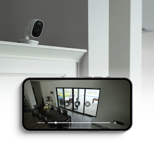 a photo of the myQ Smart Indoor Camera on a mantal and a smartphone showing live feed from the indoor camera in the myQ app.