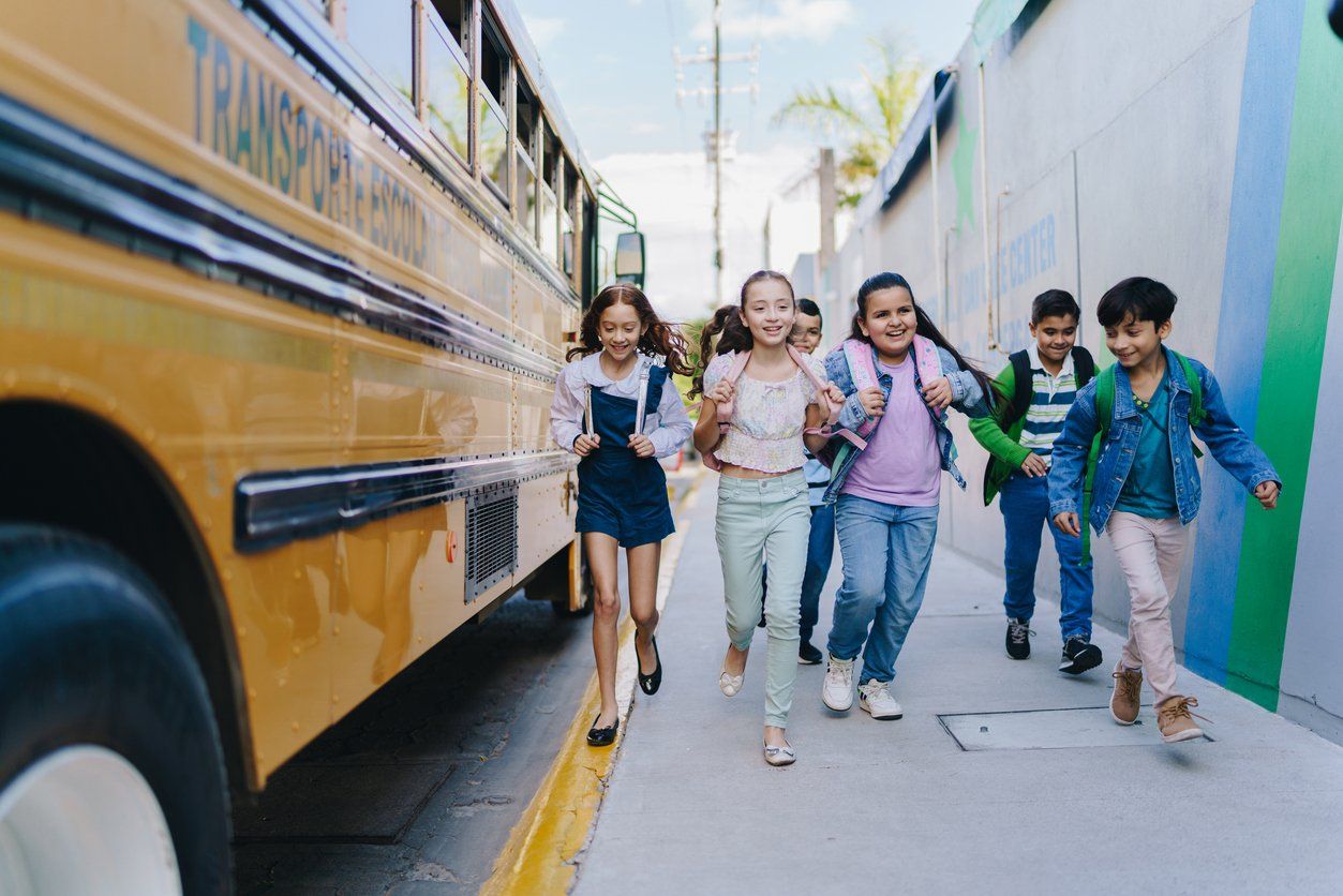 kids walking next to a school bus