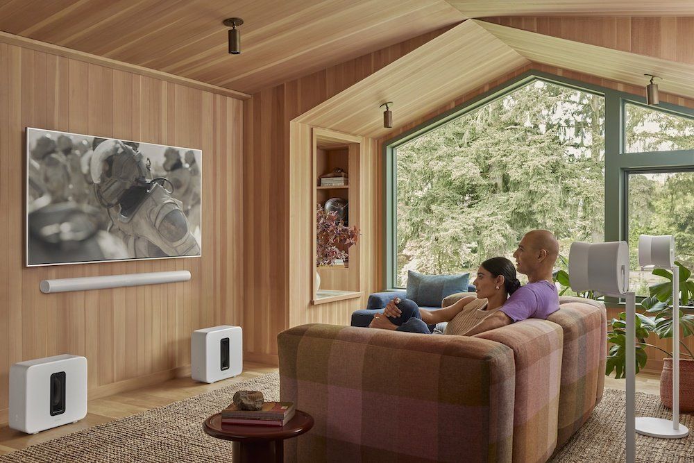 a photo of a couple watching TV in a room with Sonos Arc Ultra and Sub 4