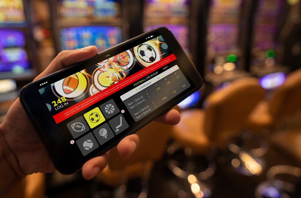 Close up of unrecognizable person holding a smartphone with a live football bet application stock photo