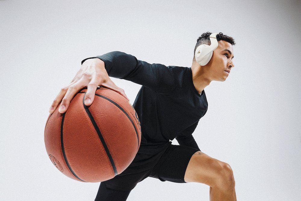 a man playing basketball with LIVV Pro Headphones