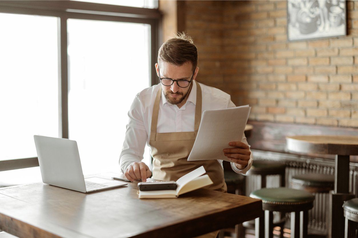 a photo of a business owner on his laptop looking at loan applications