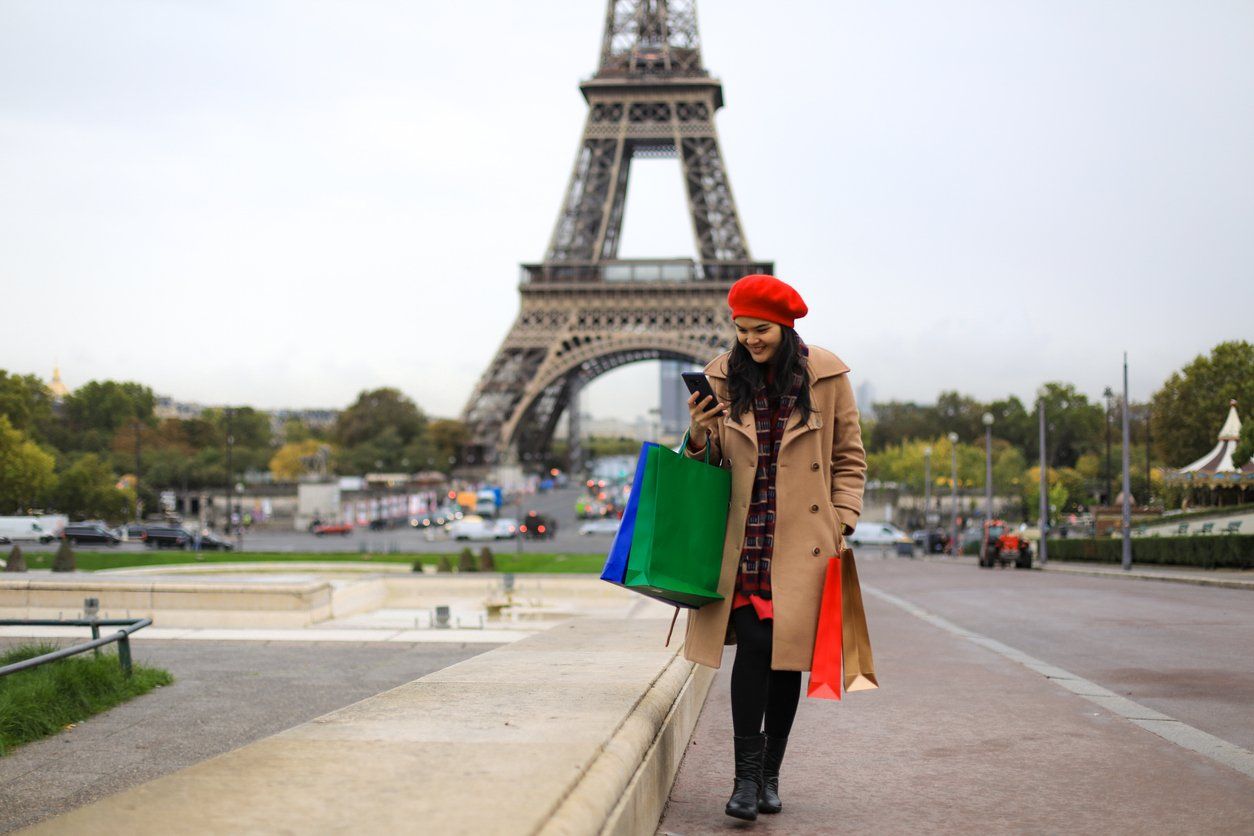 a woman waling and on her smartphone in Paris, France